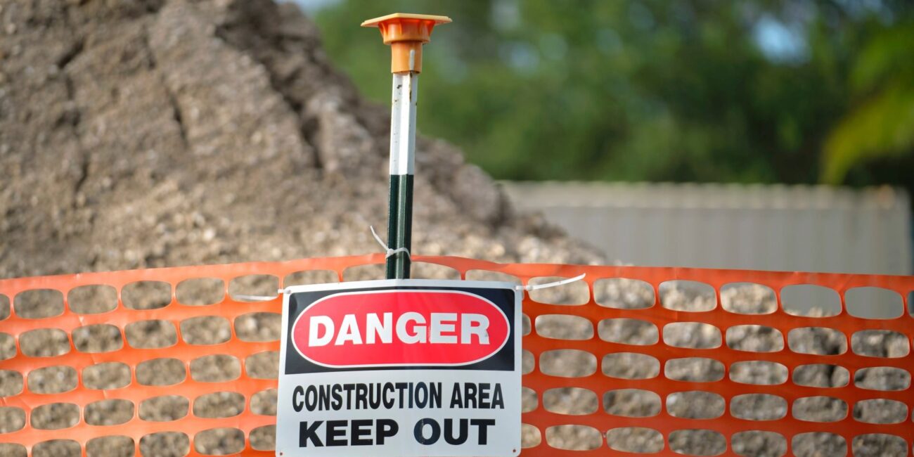 Open construction excavation at a Fresno jobsite with safety barricade fencing where after-hours trespasser injuries create premises liability exposure for contractors under California law
